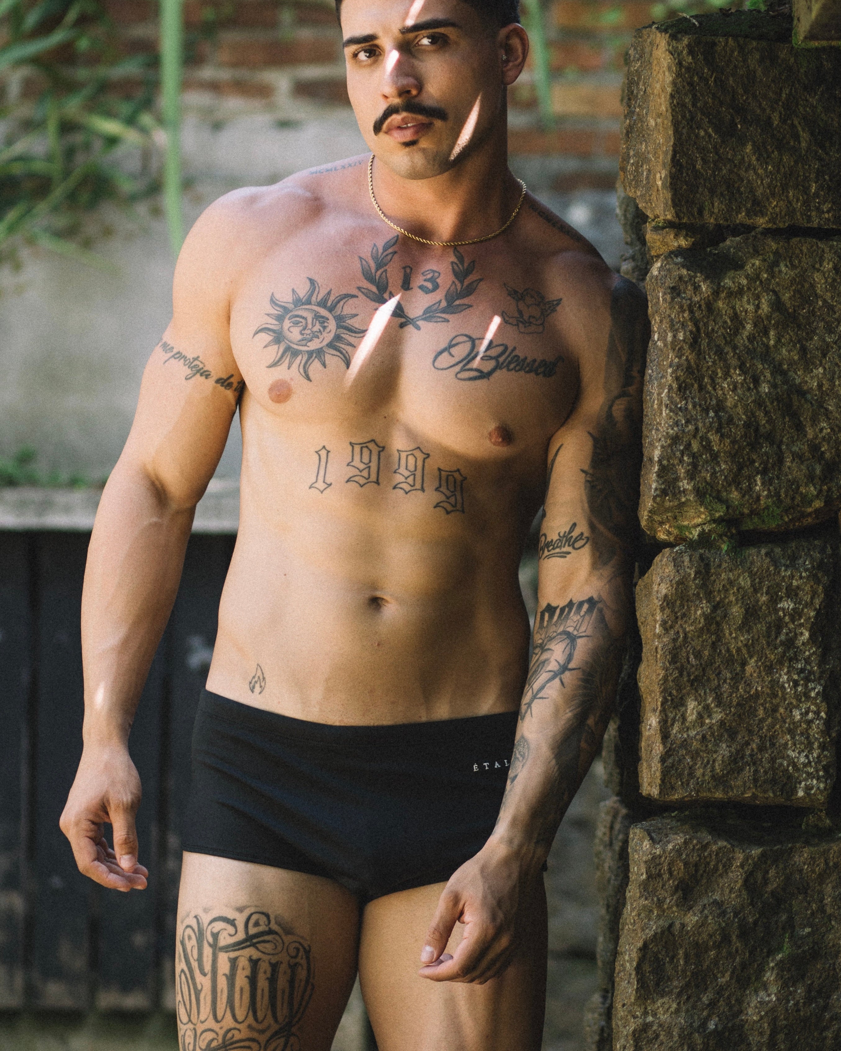 Étalon Black Swim Sunga - men's swim brief seated at pool, front angle