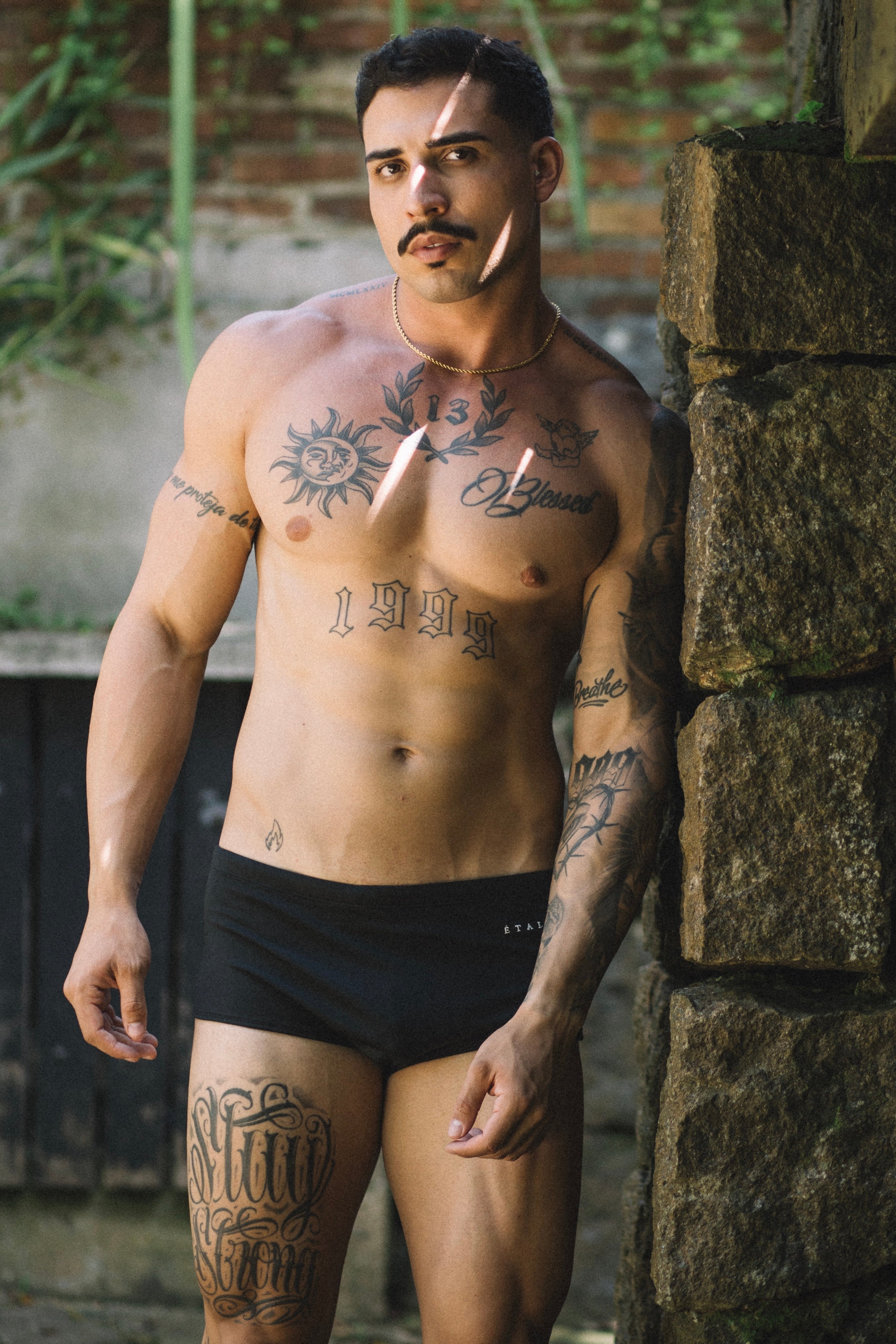 Étalon Black Swim Sunga - men's swim brief seated at pool, front angle