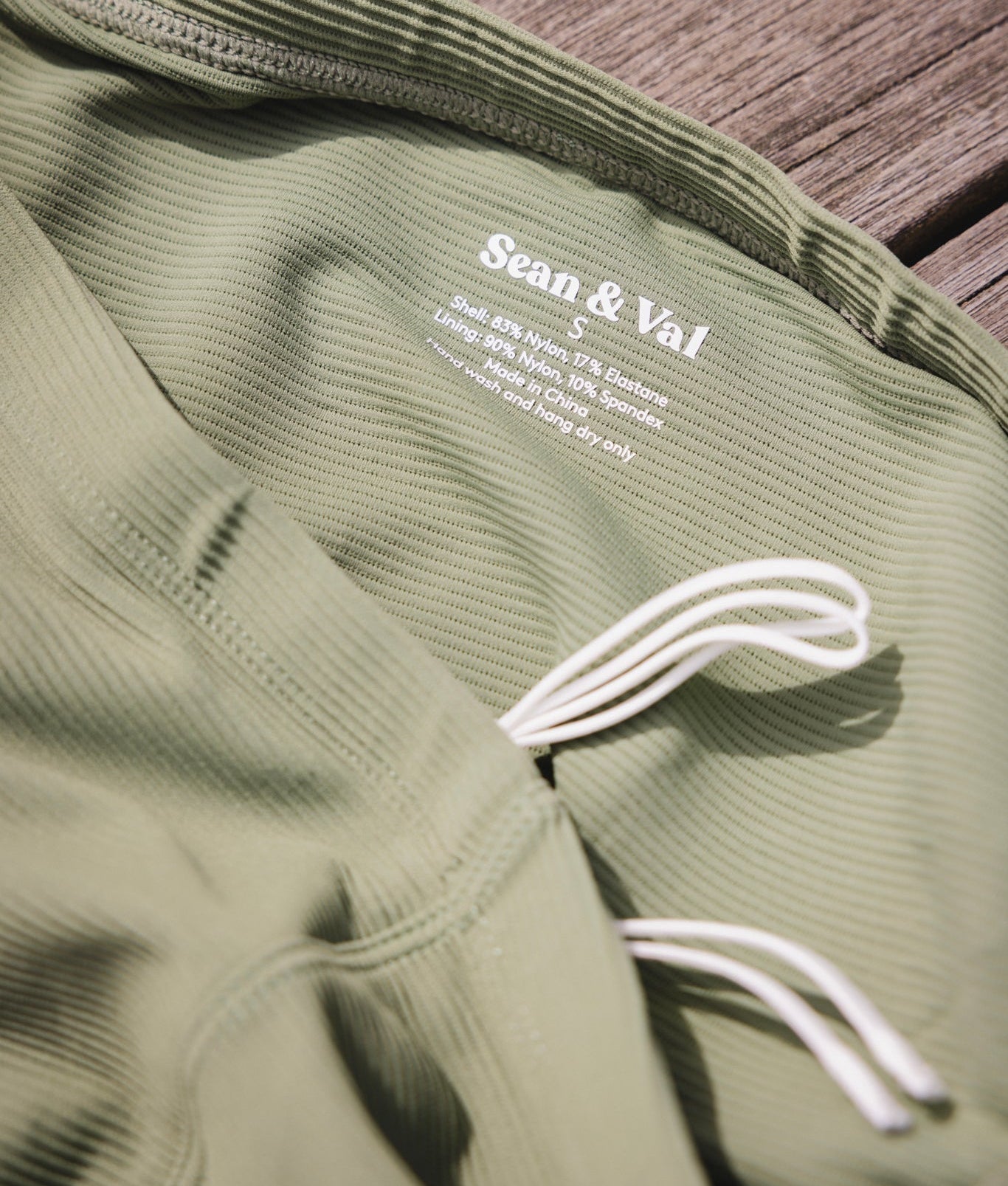 Sean & Val Ribbed Racer Brief Sage — men's swim brief lifestyle shot at beach or pool