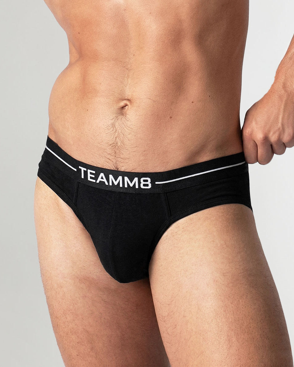 Model wearing Teamm8 Icon Brief in Onyx showing the low-rise classic brief fit