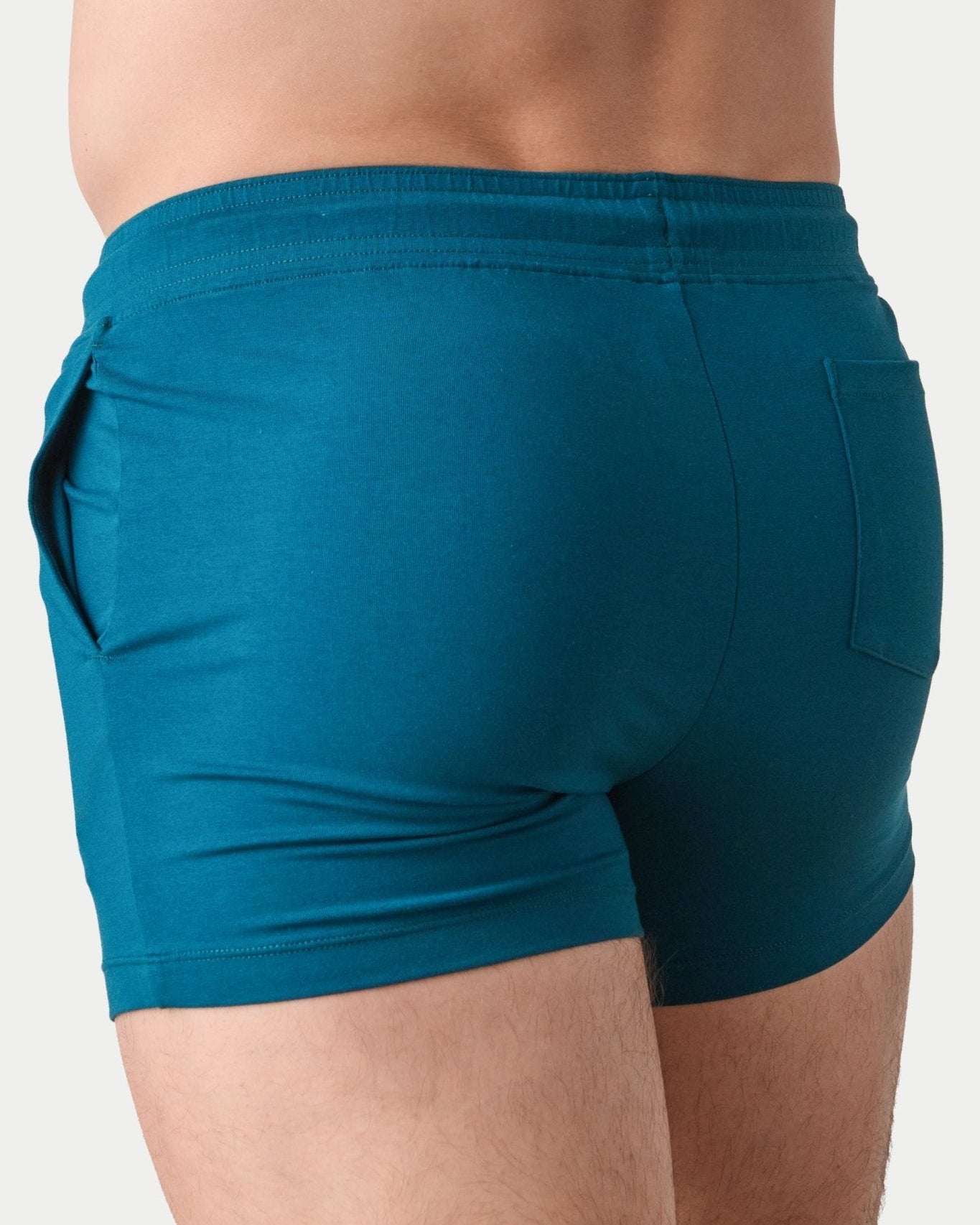 Awry Vers Short V2.1 Teal — side view showing roomy front pocket and drawstring waistband
